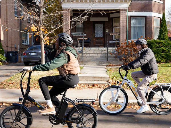 Urban couple commuting on Movin electric bikes through downtown streets