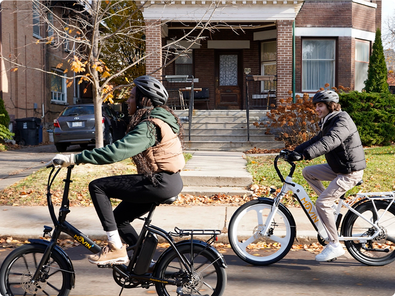 Urban couple commuting on Movin electric bikes through downtown streets